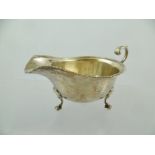 F**A**F** & CO. A SILVER SAUCE BOAT having applied gadroon rim and up-scroll handle on a plain body,