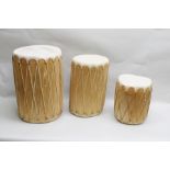 A SET OF THREE WOODEN BODIED TRIBAL DRUMS with skins to either ends, sinew secured, 38cm, 52cm &