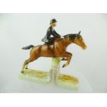 A BESWICK EARTHENWARE MODEL OF A HUNTS WOMAN ON MOUNT jumping side saddle, model no.982, issued