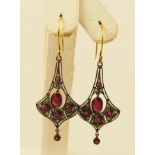 A PAIR OF "FLAPPER" STYLE RUBY AND DIAMOND GOLD COLOURED METAL DROP EARRINGS, each with six rubies