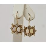 A PAIR OF GOLD COLOURED METAL EARRINGS, each set with two opals and diamonds, on wire fitting