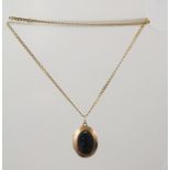A VICTORIAN STYLE AGATE AND CARVED GOLD COLOURED METAL LOCKET PENDANT, the oval front carved in