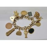 A 9CT GOLD AND YELLOW METAL CHARM BRACELET, fitted padlock clasp, also suspends a framed half