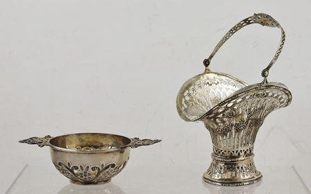 A CONTINENTAL WHITE METAL BONBON BASKET, pierced and cast with floral swags, swing handle and