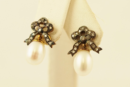 A PAIR OF VICTORIAN STYLE GOLD COLOURED METAL SET EARRINGS, each having a stud with a bow of