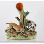 A 19TH CENTURY STAFFORDSHIRE POTTERY SPILL HOLDER, dogs chasing a rabbit into his hole amidst the