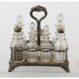 AN EPNS SIX BOTTLE CRUET having tray stand with central handle and matching facetted lead crystal