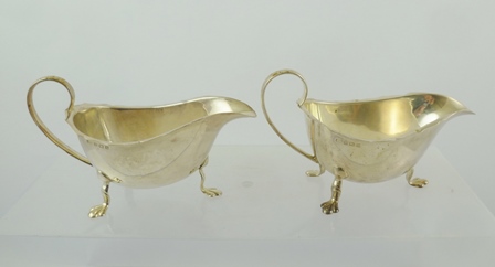 ADOLF SCOTT LTD A PAIR OF CHIPPENDALE STYLE SILVER SAUCE BOATS each having cut rim with upswept wire