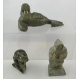 AN INUIT CARVED SOFT STONE WALRUS AND TWO ESKIMO FIGURES, inscribed to base, tallest 16cm