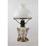 AN EARLY 20TH CENTURY SITZENDORF PORCELAIN TABLE LAMP, having opal glass shade, basket reservoir