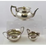 JAMES SCOTT A GEORGE III IRISH SILVER THREE-PIECE TEA SET, each of squat form with demi-reeded belly