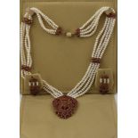 A RUBY AND FRESHWATER PEARL MOUNTED GILT METAL NECKLACE having ornate multi gem pendant on four