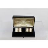 ROBERT PRINGLE AND SONS A PAIR OF EDWARDIAN SILVER NAPKIN RINGS, having engraved swag decoration,