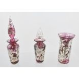 THREE SILVER OVERLAID ITEMS OF PINK GLASS comprising two scent bottles with stoppers and a small