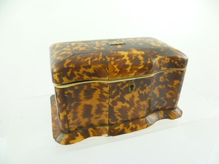 AN EARLY 19TH CENTURY TORTOISESHELL TEA CADDY of serpentine breakfront form, the hinged lid