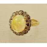 AN OPAL AND DIAMOND CLUSTER RING having cabochon oval central stone with eight diamonds around in