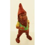 AN EARLY 20TH CENTURY HAND PAINTED CERAMIC GNOME, standing with his hands upon his fat belly, and