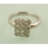 A MODERN PLATINUM SET DIAMOND DRESS RING, having twelve stone tablet head, size N tight