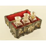 A LATE 19TH CENTURY PAPIER MACHE BOX containing three scent bottles with stoppers, casket is