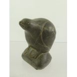 AN INUIT CARVED AND SCULPTED SOFT STONE FIGURE OF A PENGUIN, on a rock, unsigned, 11cm high