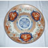 A JAPANESE IMARI CHARGER decorated in the iron red, cobalt blue and gilded, three panels of