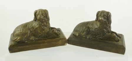 A PAIR OF CAST AND PAINTED MANTEL ORNAMENTS fashioned as recumbent dogs, 12cm x 17cm
