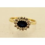 A 9CT GOLD SAPPHIRE AND DIAMOND DRESS RING having oval central sapphire and fourteen 8/8 diamonds