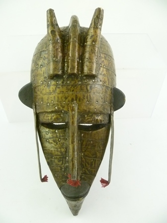 A POSSIBLY AFRICAN TRIBAL MASK, having allover nailed metal sheeting, 34cm high