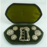 E. MANDER AND SON AN EDWARDIAN ART NOUVEAU SET OF BUTTONS AND BUCKLE, cast silver, decorated with