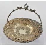 AN EDWARDIAN SILVER PLATED FRUIT BASKET, having embossed decoration with cast swing handle, 30cm