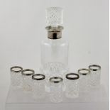 A FOREIGN SILVER COLOURED METAL MOUNTED LEAD CRYSTAL DECANTER AND SEVEN DRINKING VESSELS, with