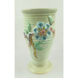 A CLARICE CLIFF VASE of moulded ridged form, hand painted floral design on a green ground, moulded