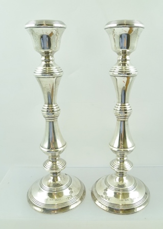 W.I. BROADWAY & CO. A PAIR OF 20TH CENTURY SILVER CANDLESTICKS of early Georgian design,