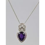 AN AMETHYST AND DIAMOND RHODIUM FINISHED WHITE GOLD COLOURED METAL SET PENDANT, having a central