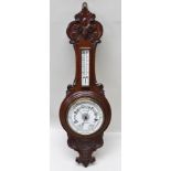 THOMAS WALLIS & CO LTD OF HOLBAN CIRCUS, LONDON AN EDWARDIAN CARVED OAK CASED BAROMETER AND
