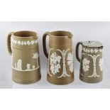 THREE 19TH CENTURY BROWN STONEWARE JUGS each applied with white slipware decoration, includes