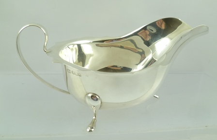 EDWARD VINER LTD. A CHIPPENDALE STYLE SILVER SAUCE BOAT, having cut shaped rim, plain up-scrolled