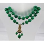 A GENEROUS JADEITE FACETED BEAD AND HAND KNOTTED NECKLACE with silver gilt immortal drop, 86cm long