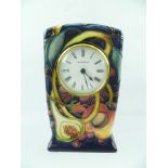 A MOORCROFT MANTEL CLOCK, circa 2000, "Queens Choice" pattern with figs, on a dark cobalt blue