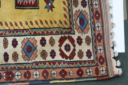 A TURKISH ELMAZ RUG having central yellow field with stylized geometric designs in blue, green, - Image 3 of 4