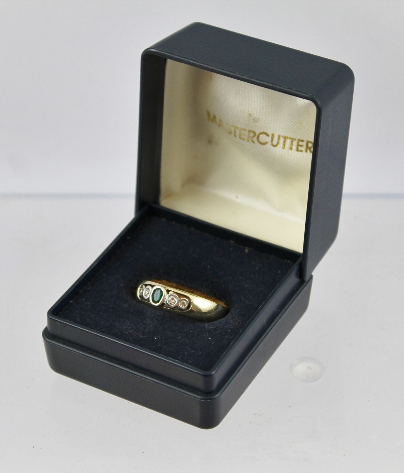 A 9CT GOLD GYPSY STYLE RING inset with an emerald and four diamonds, stamped .585, size R, gross