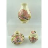 THREE PIECES OF MOORCROFT, having ivory ground, piped and painted with the "Pink Magnolia"