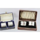 TWO PAIRS OF SILVER NAPKIN RINGS, one bright cut with scroll decoration and monogrammed, the other