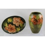 A MOORCROFT VASE green ground with Hibiscus decoration, bears paper label to base "Potters to the