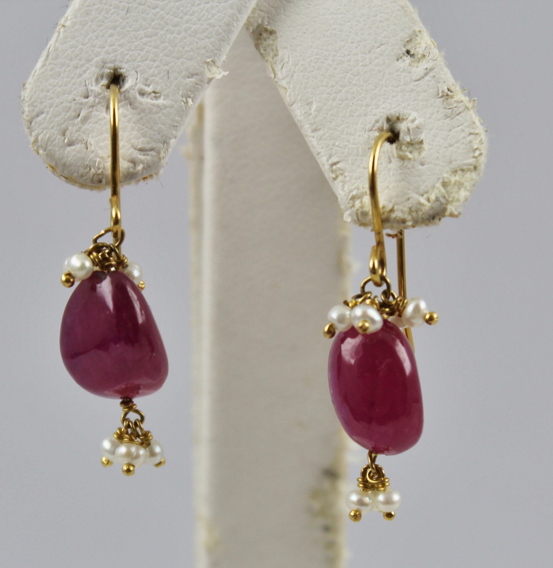 A PAIR OF GOLD COLOURED METAL MOUNTED RUBY AND SEED PEARL EARRINGS, each having a polished pebble