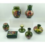 A COLLECTION OF SEVEN PIECES OF GREEN GROUND MOORCROFT CERAMICS, includes a ginger jar and cover