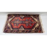 A TURKISH VILLAGE DOSEMEALTI RUG, having brick red field, with stylized geometric decoration,