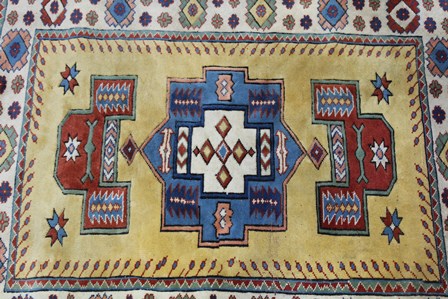 A TURKISH ELMAZ RUG having central yellow field with stylized geometric designs in blue, green, - Image 2 of 4