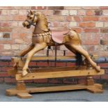 A 20TH CENTURY CARVED WOOD ROCKING HORSE with horse hair tail, on trestle stand, 109cm high