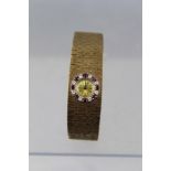 A LADY'S "BUECHE GIROD" 9CT GOLD INTEGRAL BRACELET WATCH, having bark textured bracelet, a bezel